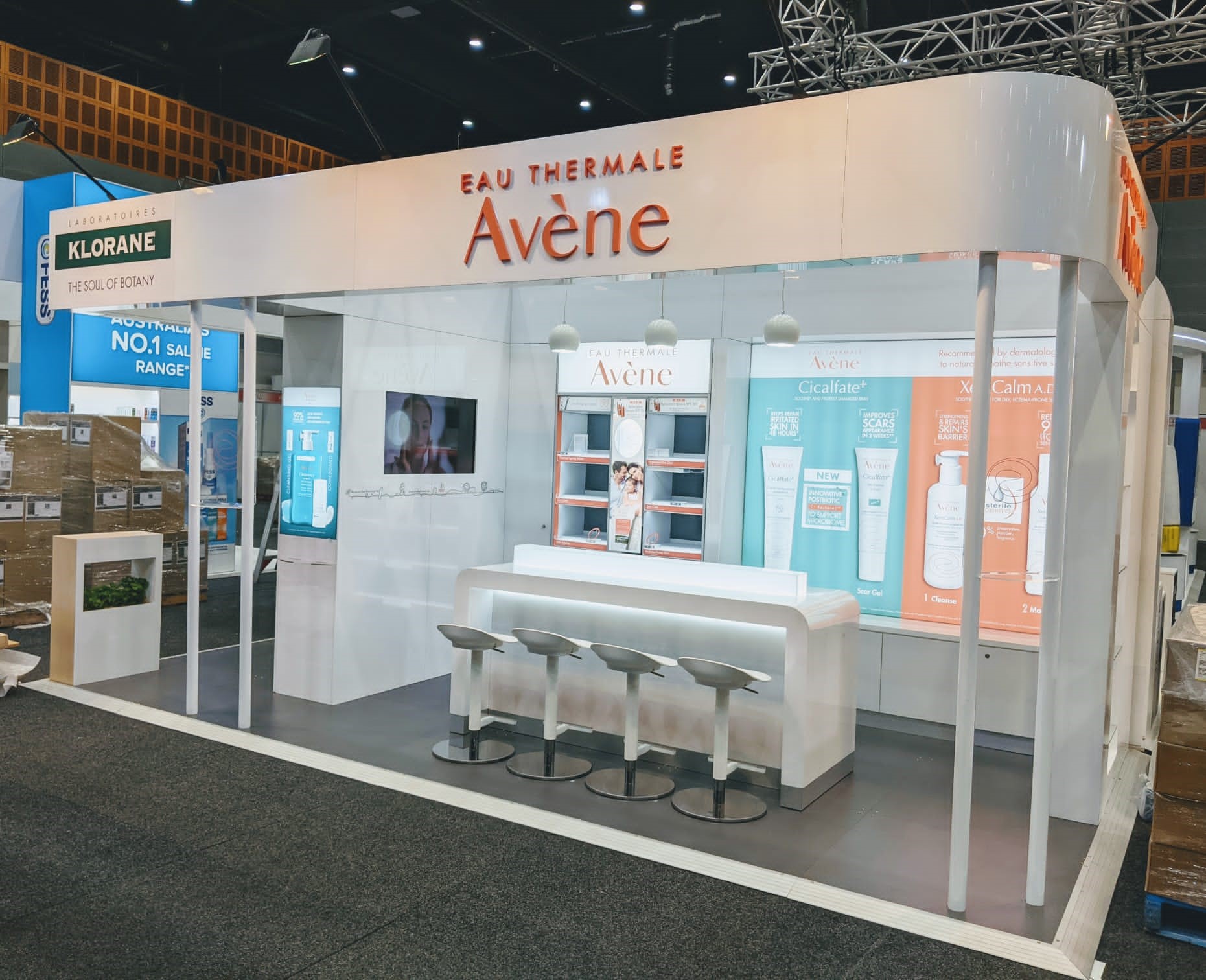 Avene expo stand empty with signage and a table with stools