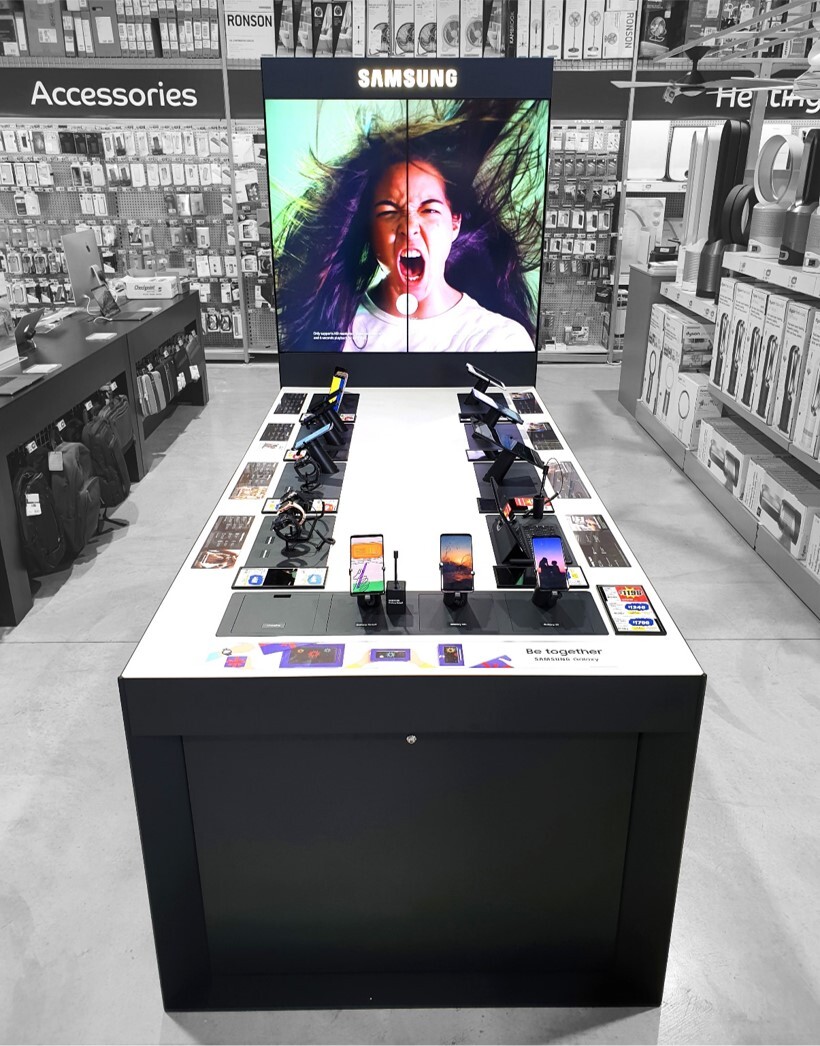 In-store focus on Samsung phone display with multiple phones ready to use