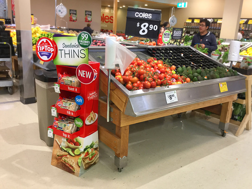 Tip Top promoted product display stand next to fruit in Coles